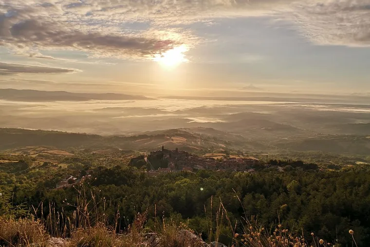 Sunrise over the wooded hills below Castell’Azzara, mist lying in the valleys