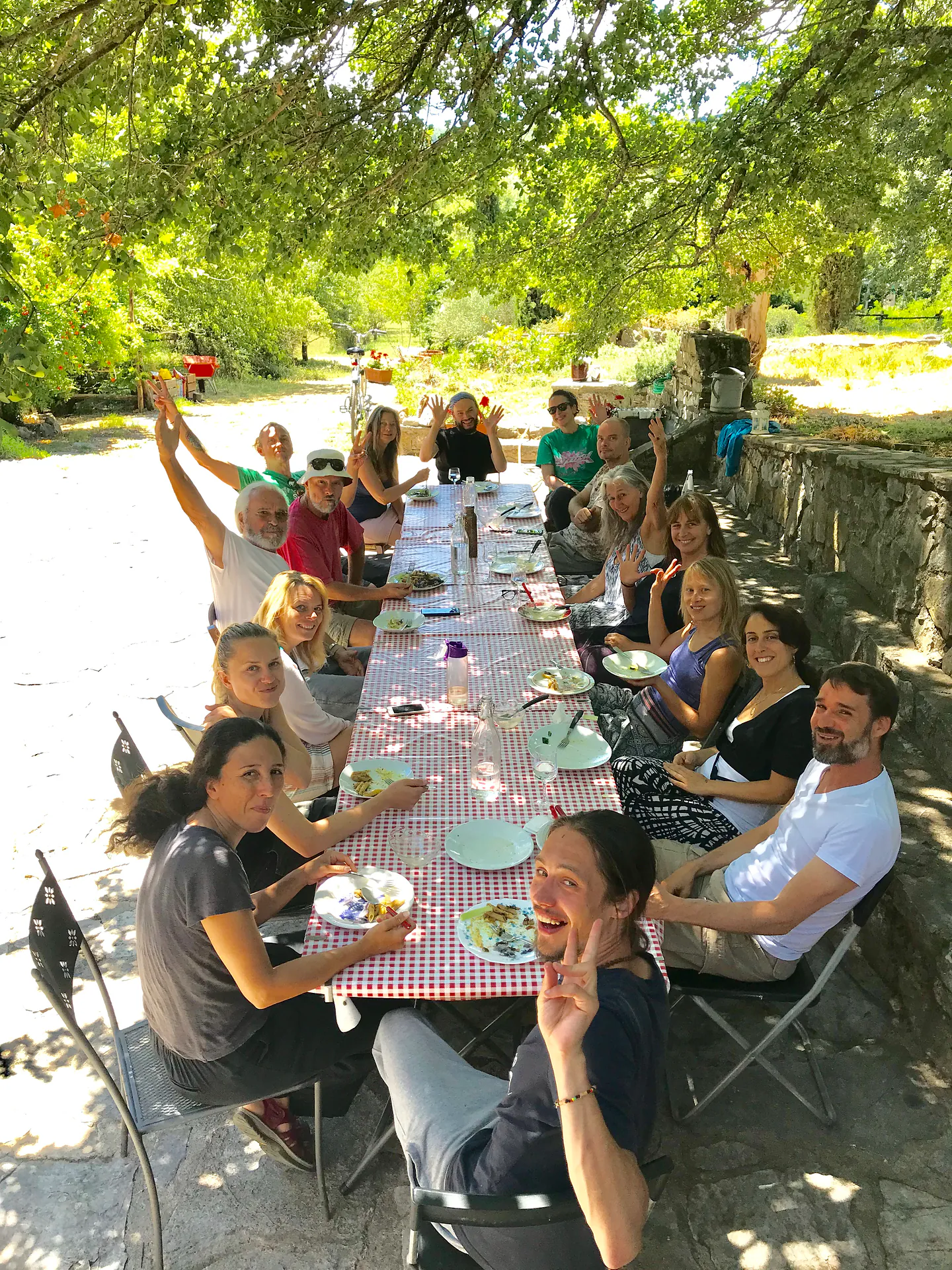 A long table outdoors, people eating together