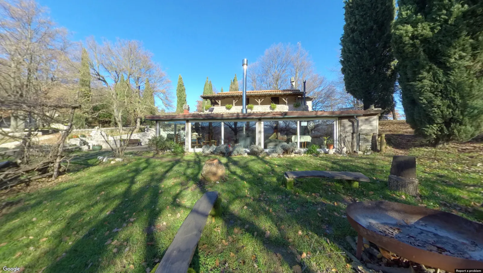 The lawn at ASHA in front of the Arc, a long glass-fronted building among cypresses and bare winter trees